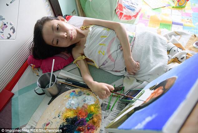Zhang carefully mixes and places her oil colours on a painting that she's working on