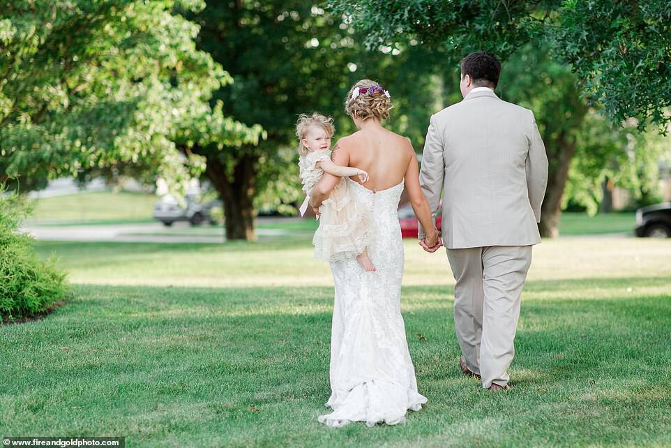 Happily ever after: After Dalton and Jimmy Joe's wedding ceremony, the bride removed the wrap an held the toddler in her arm, revealing that she was wearing an adorable ivory-colored lace gown that the toddler wore for the weddingÂ 